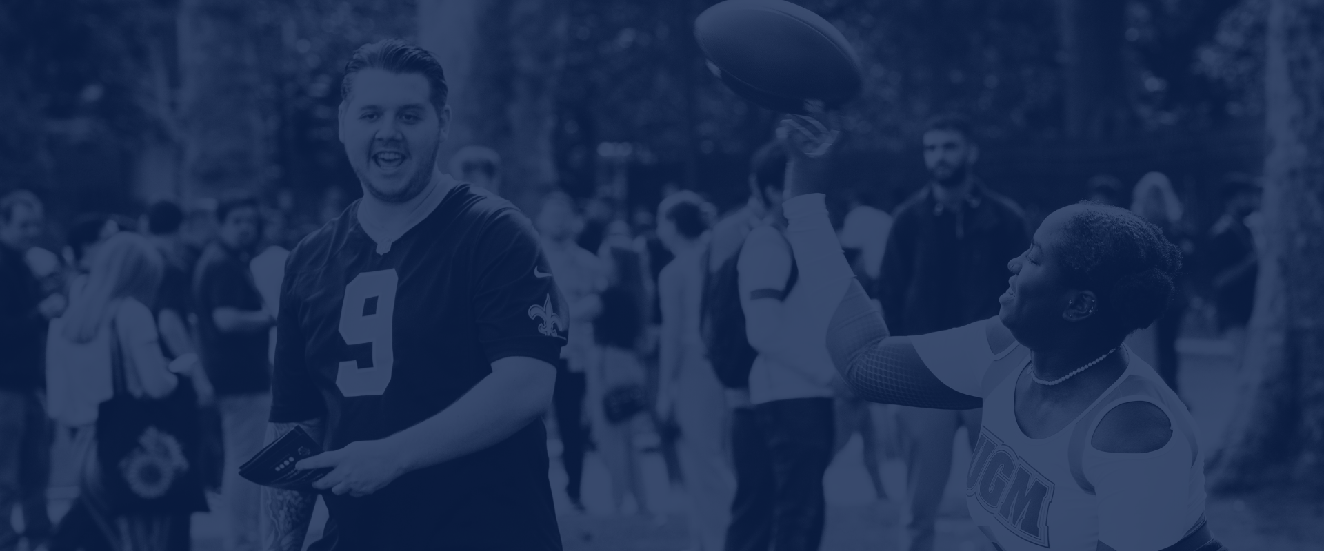 man smiling as woman throws rugby ball faded in background