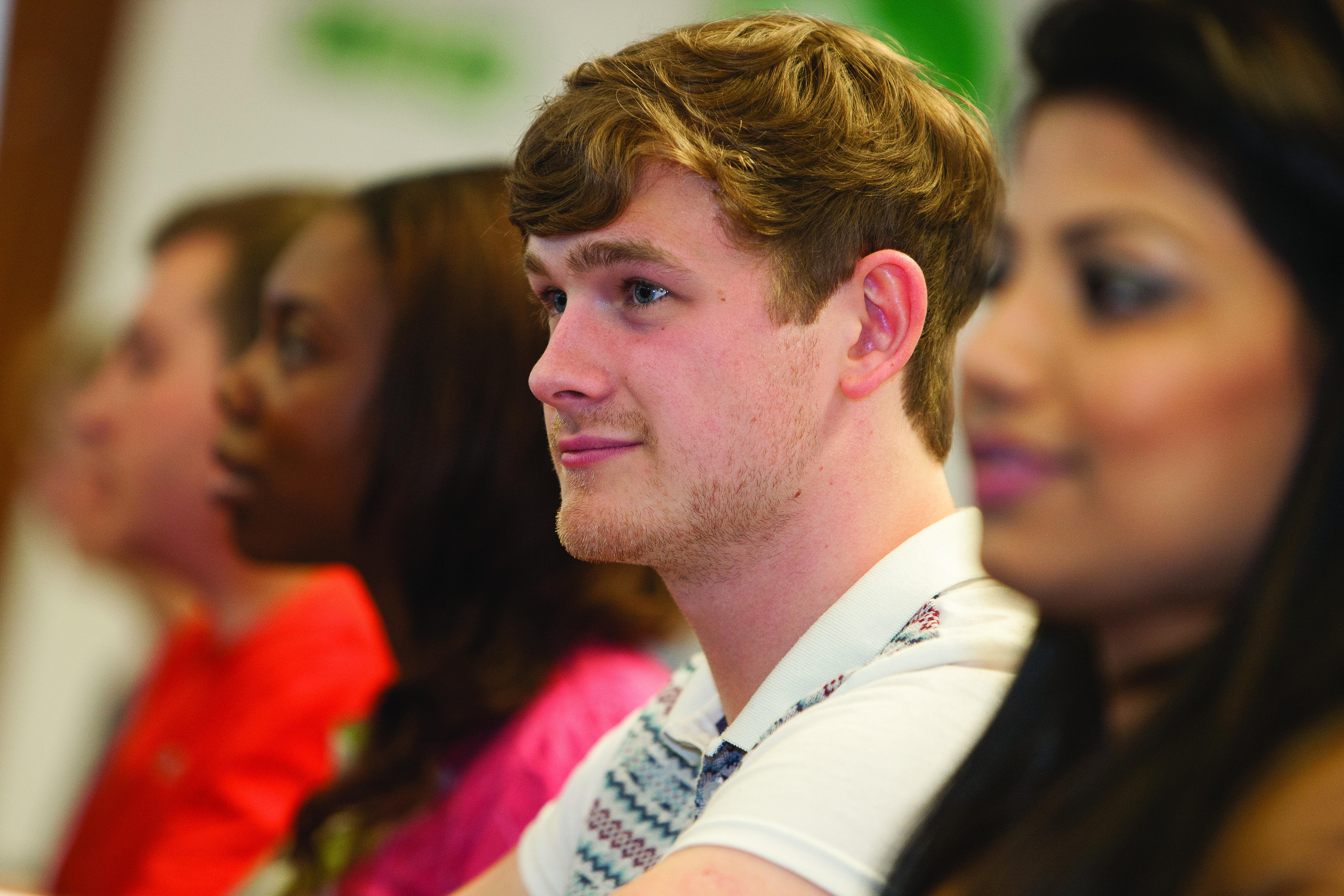 male student in crowd smiling