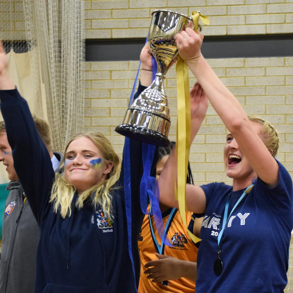 Students with Varsity trophy after winning