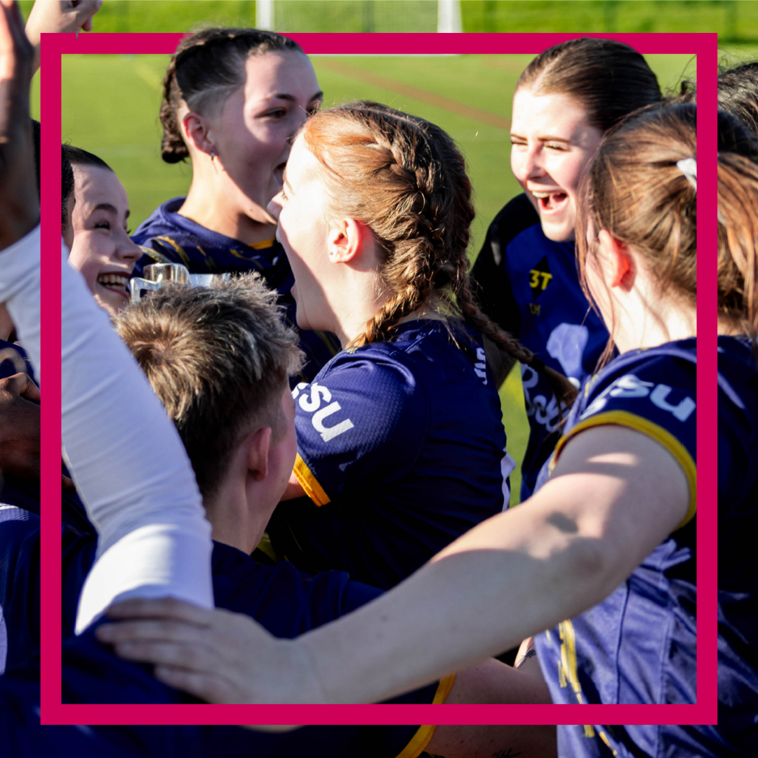 womens football team in a group huddle celebrating a win