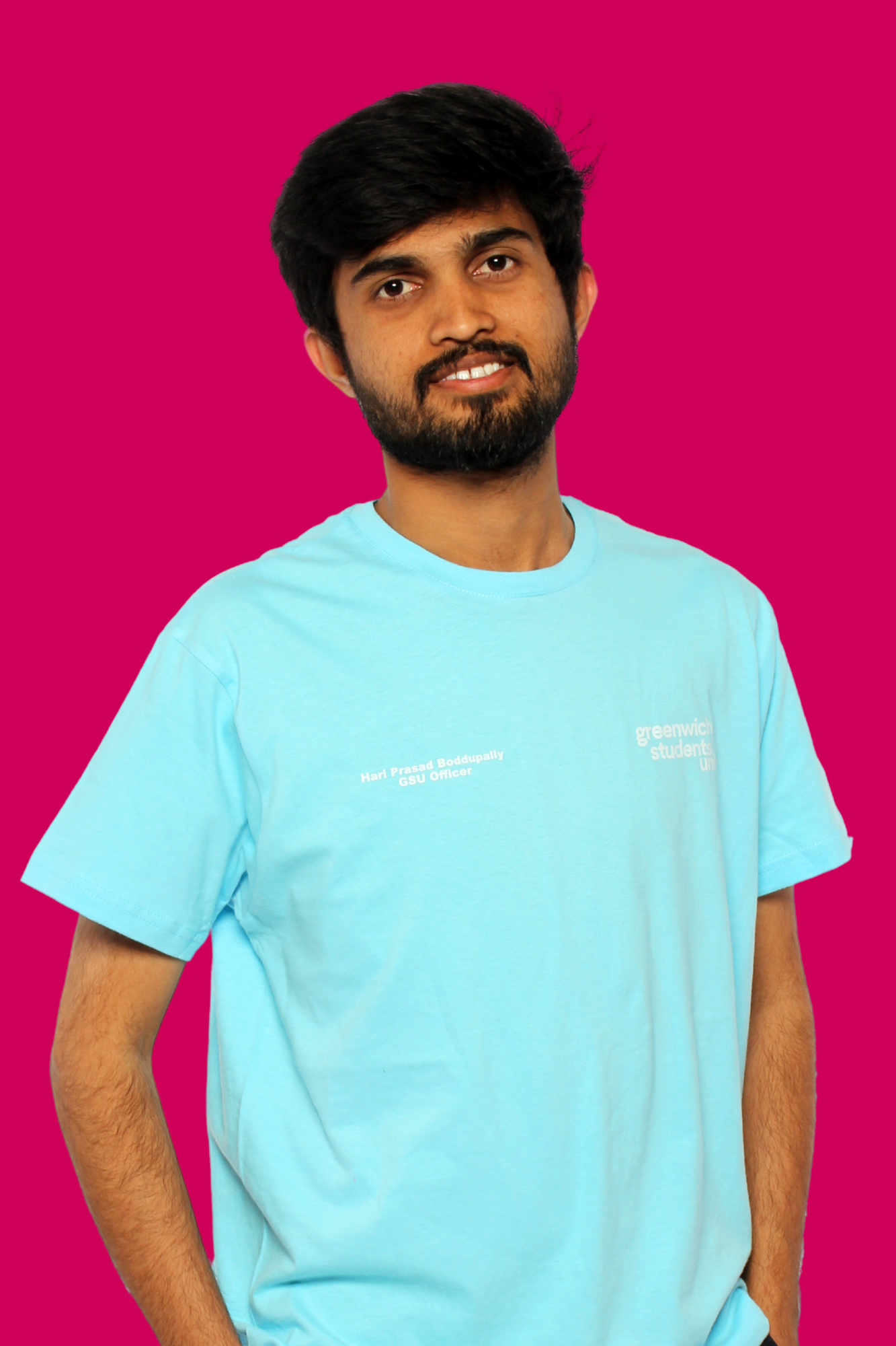 Hari smiling at the camera wearing a blue t shirt