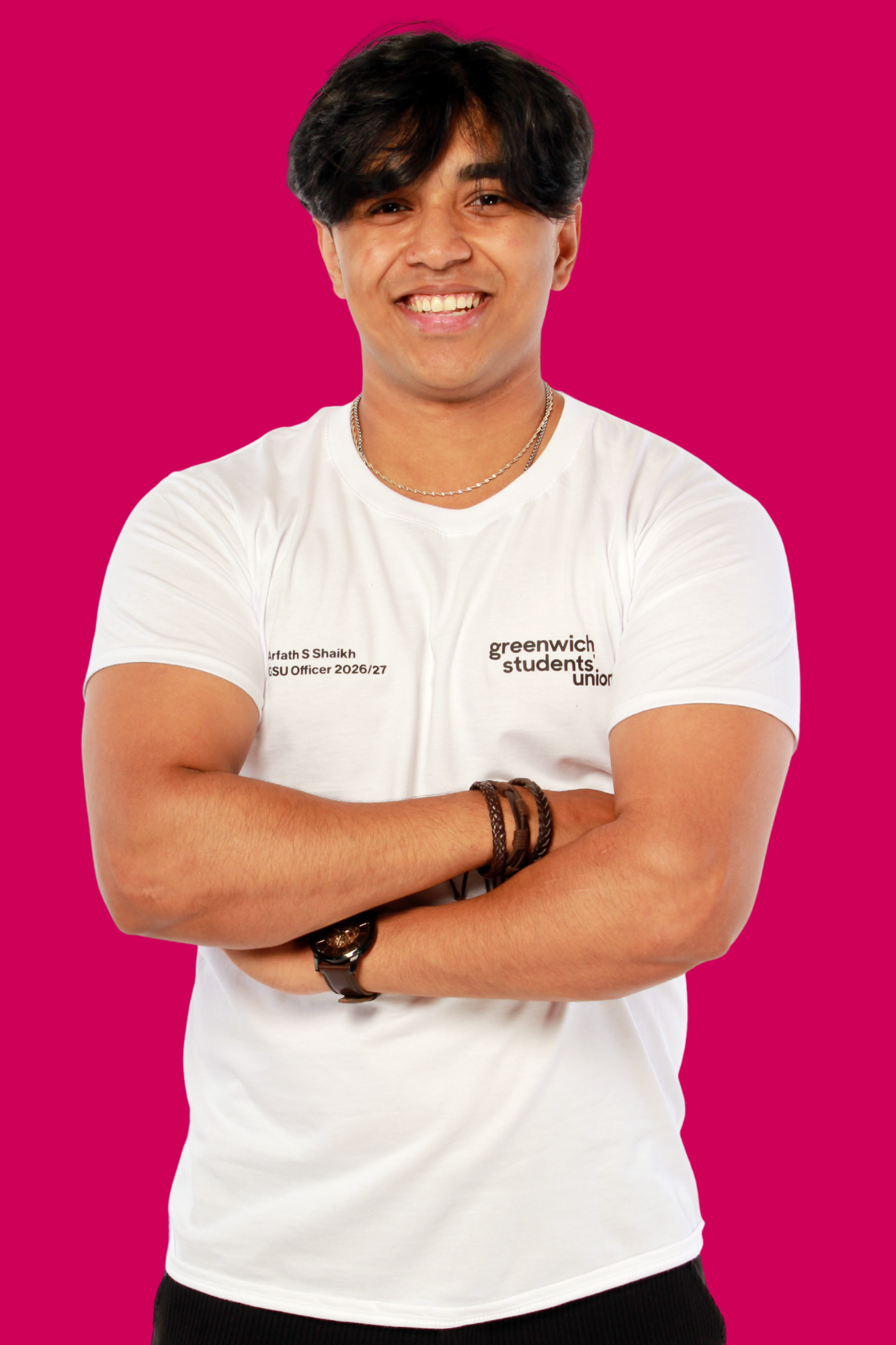 Arfath facing and smiling at the camera with his arms crossed