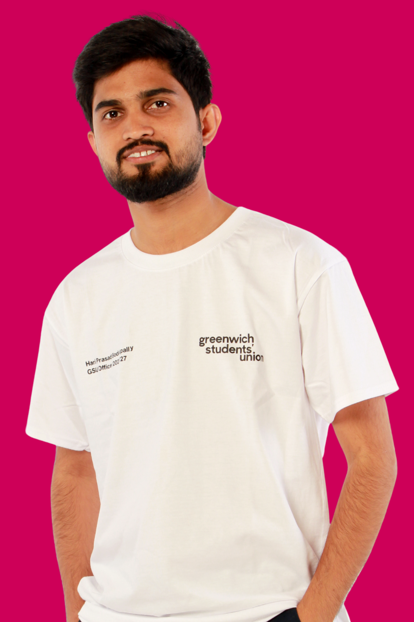 Hari smiling at the camera wearing a white t shirt