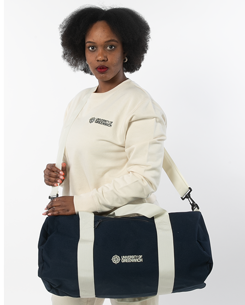 Woman in a beige tracksuit, holding a large navy cotton bag with University logo on it