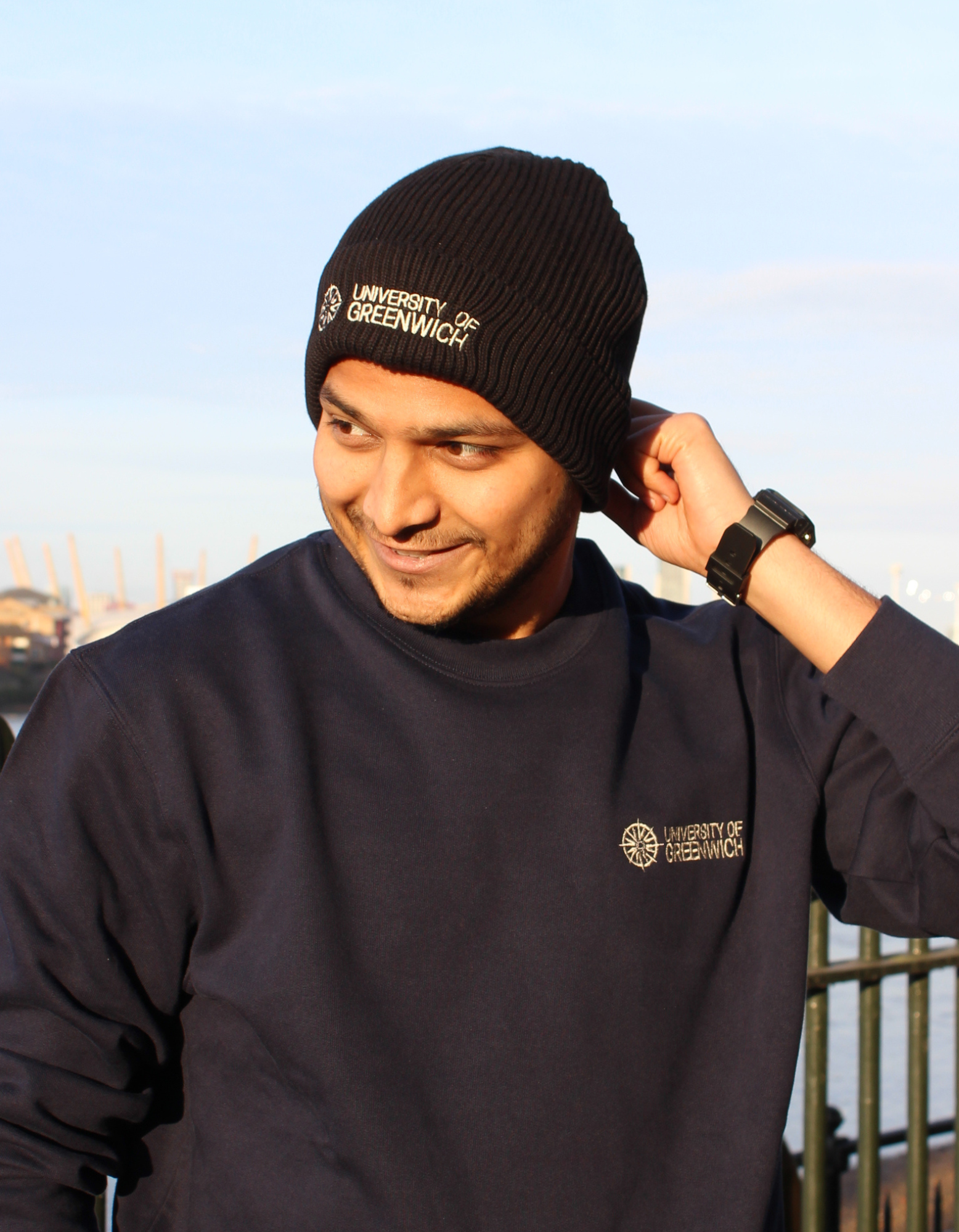 Man wearing a black beanie and navy sweatshirt with University of Greenwich written across it