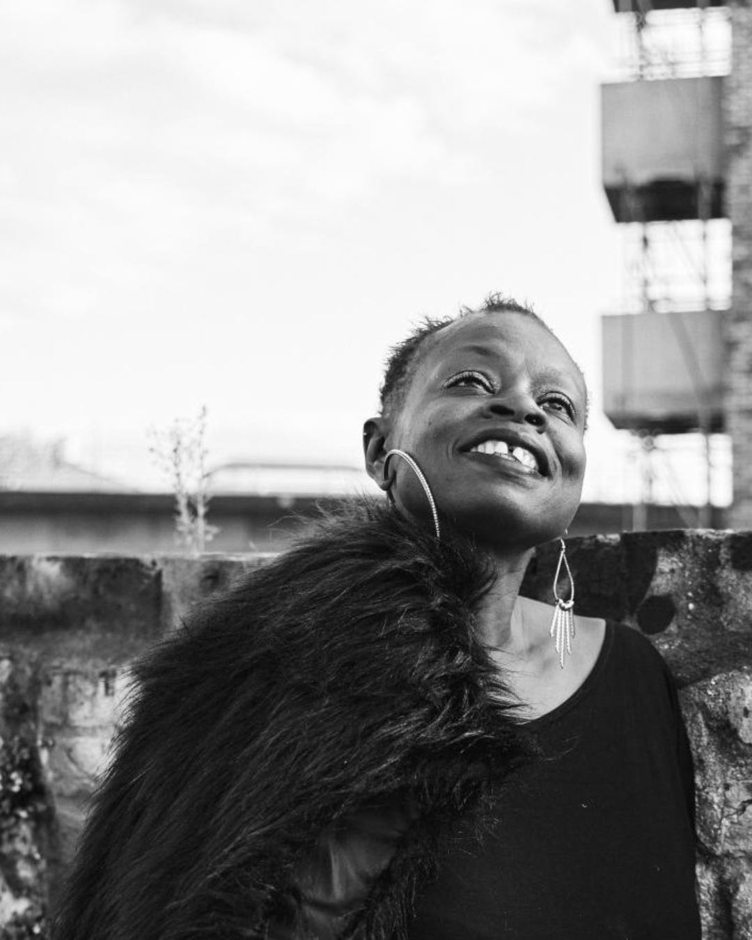 louise smiling and looking up, photo has a black and white filter