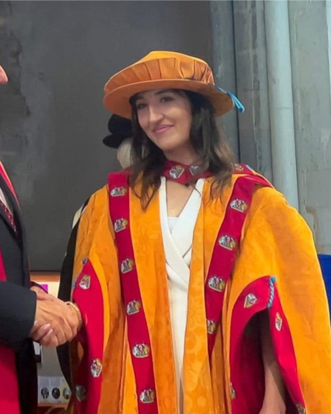 Meena in cap and gown at a graduation ceremony