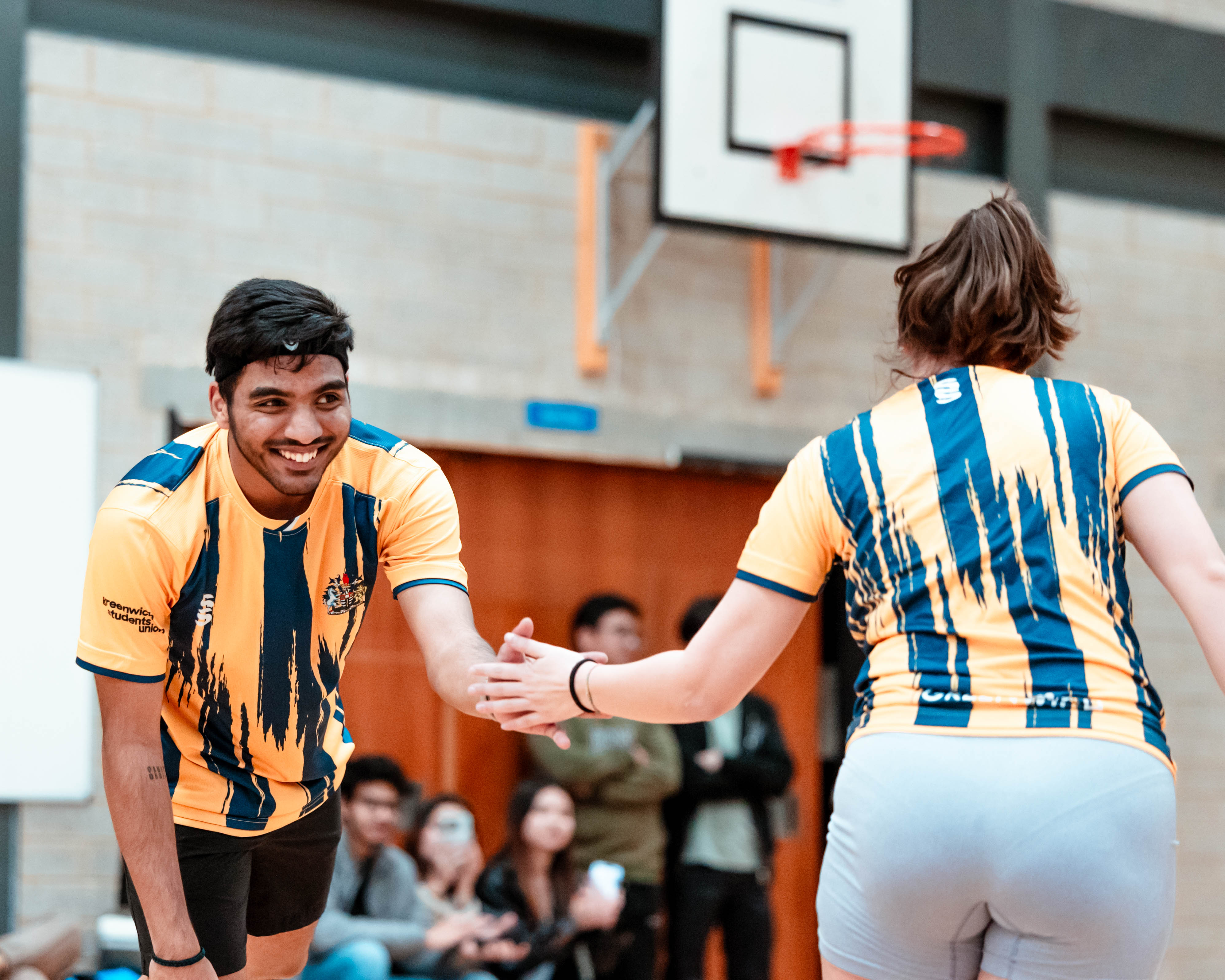 badminton players smiling and shaking hands 