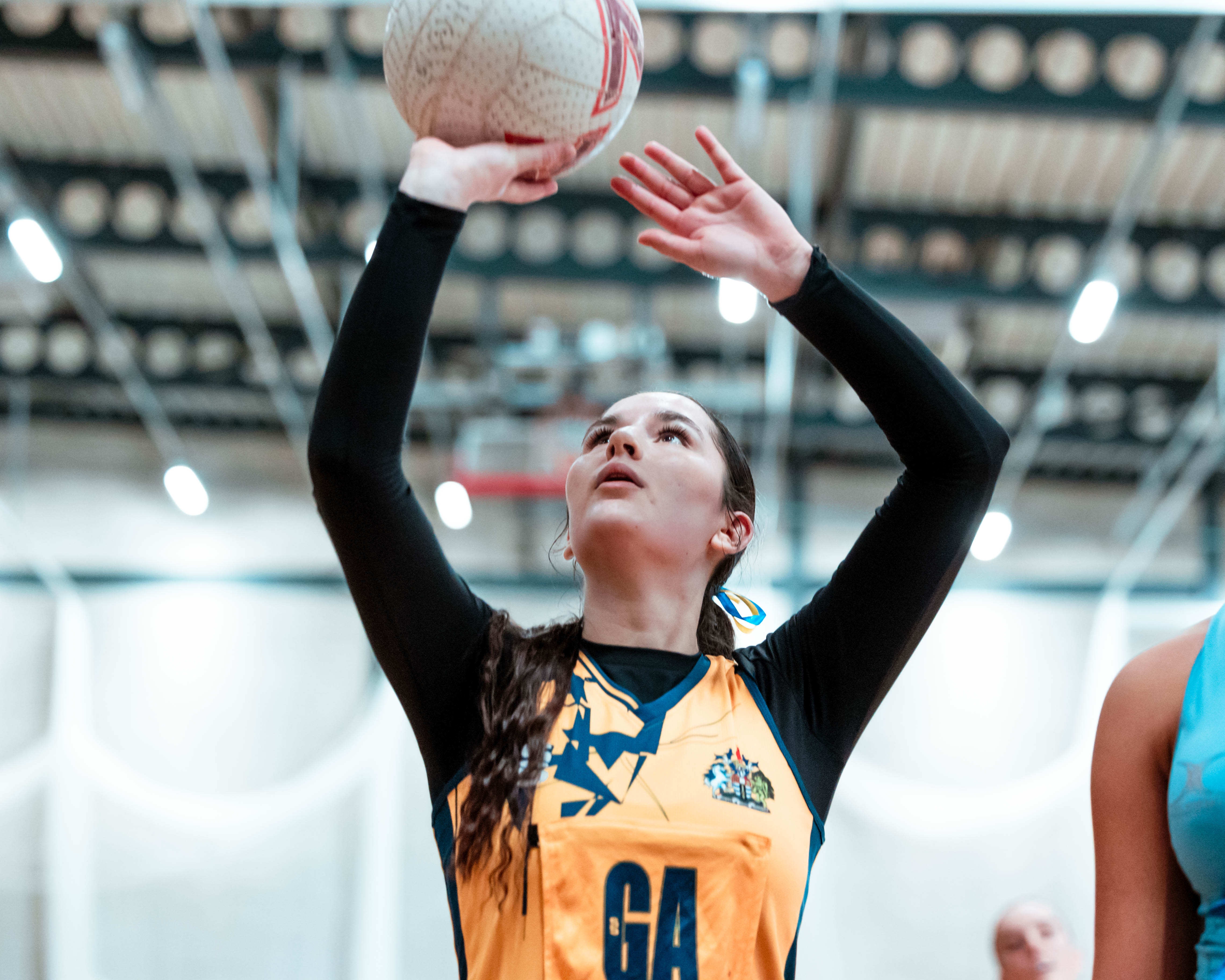 netball player making a shot with the ball, mid air