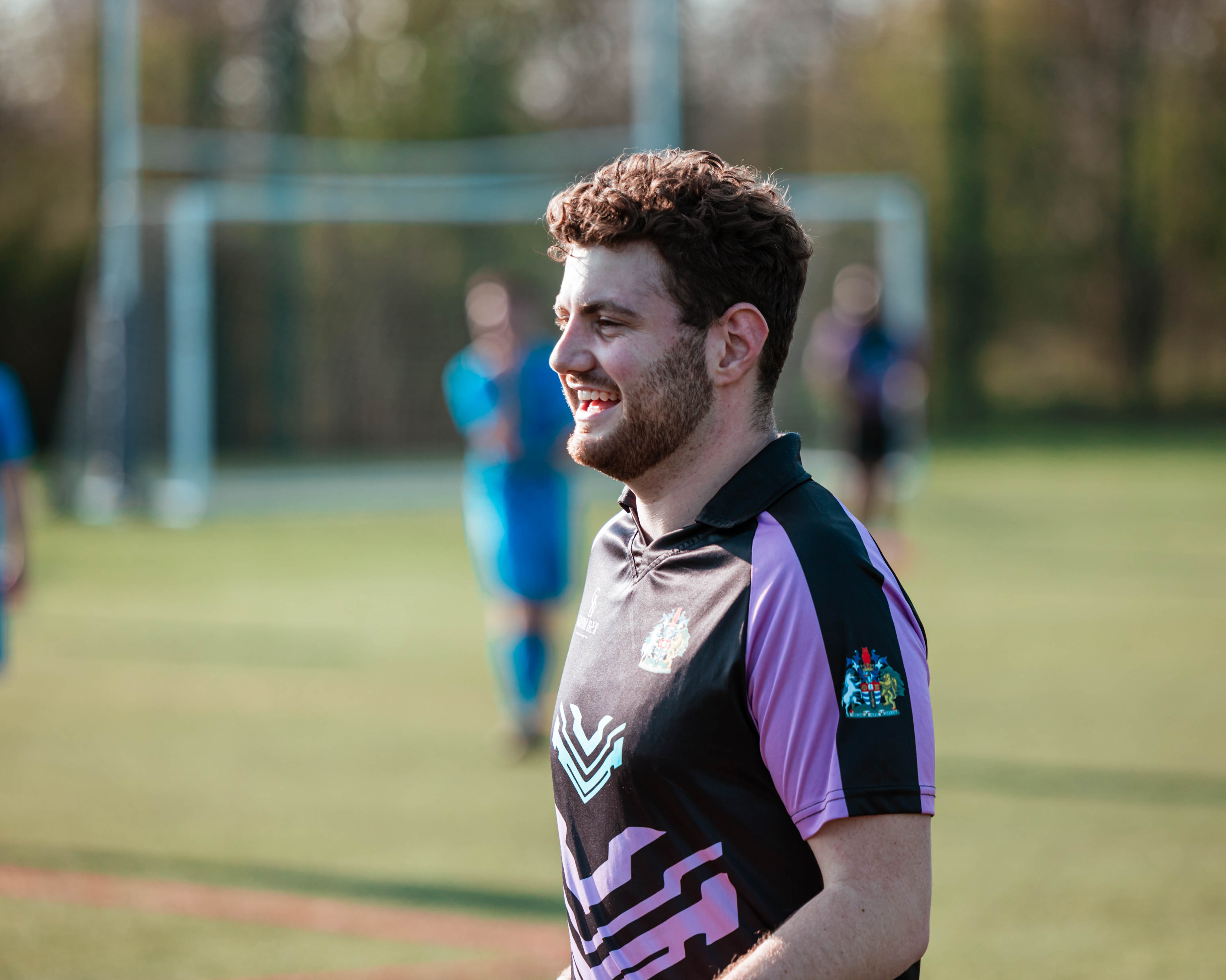 photo of football player walking on pitch with a smile