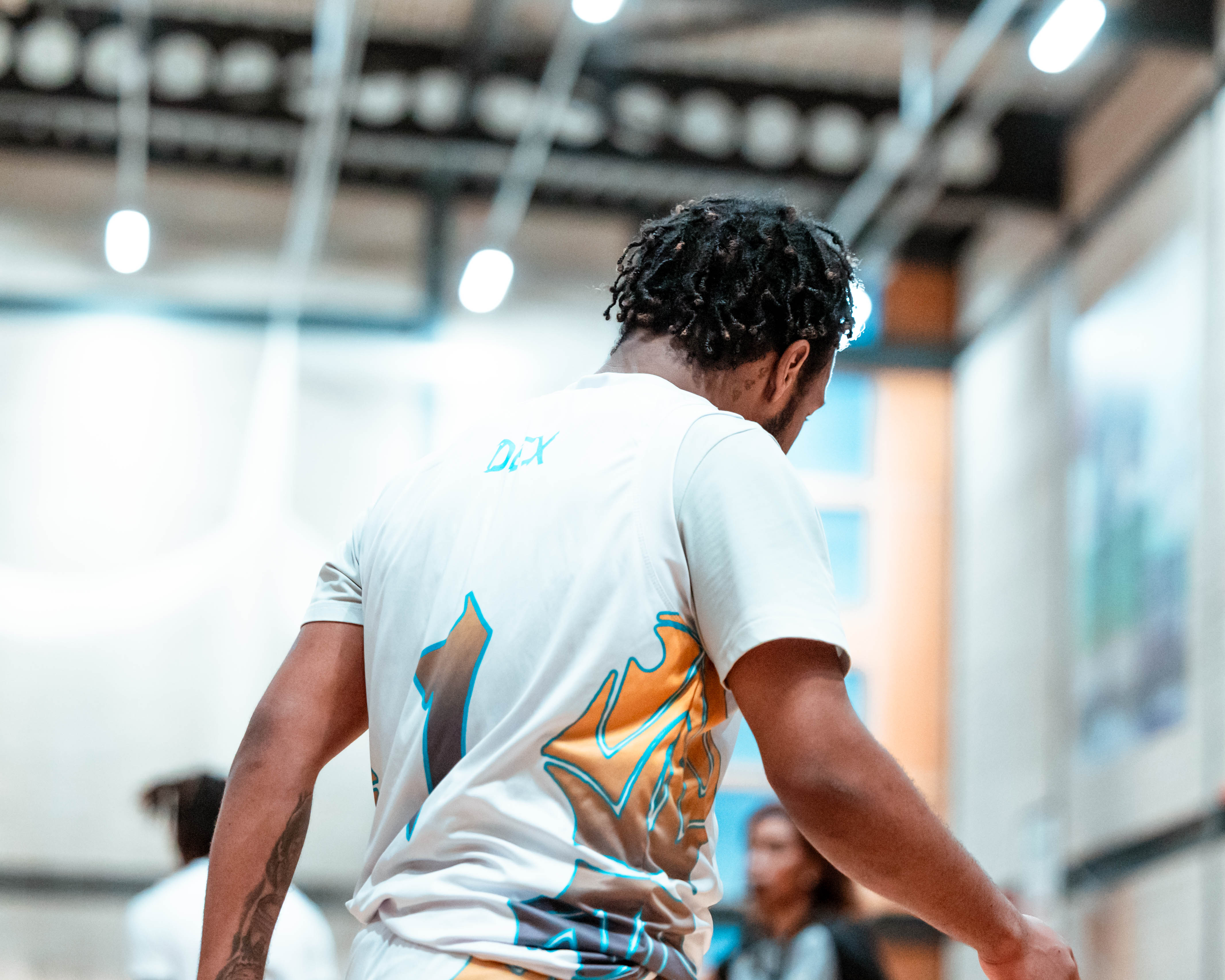 back of basketball player, showing team greenwich logo on back of tee