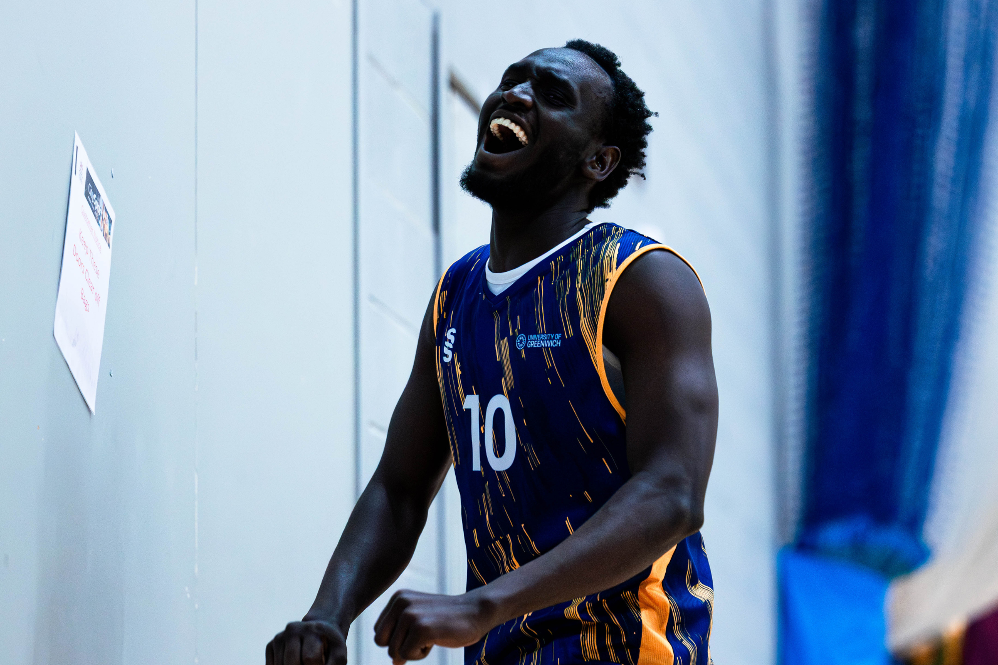basketball player celebrating, fists clenched smiling up