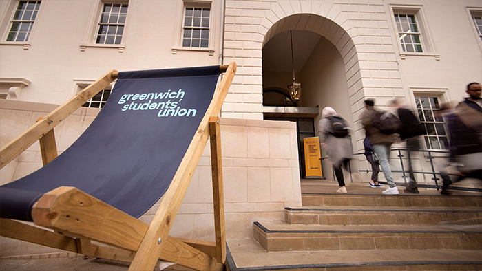 Giant deck chair with GSU logo on it, sat outside an exterior staircase where people are walking up and down 