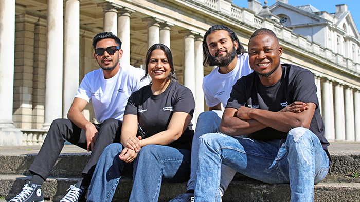 Photo of GSU Officers sat on staircase on Greenwich campus on a summer's day, smiling to camera