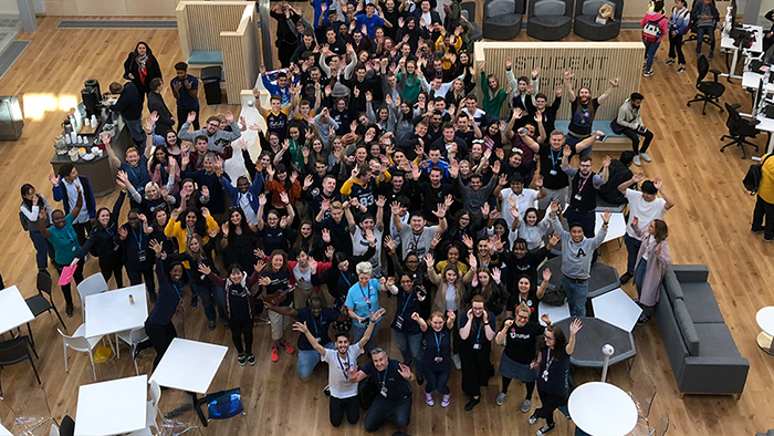 Aerial shot of tens of people - GSU staff and students - smiling and waving to camera