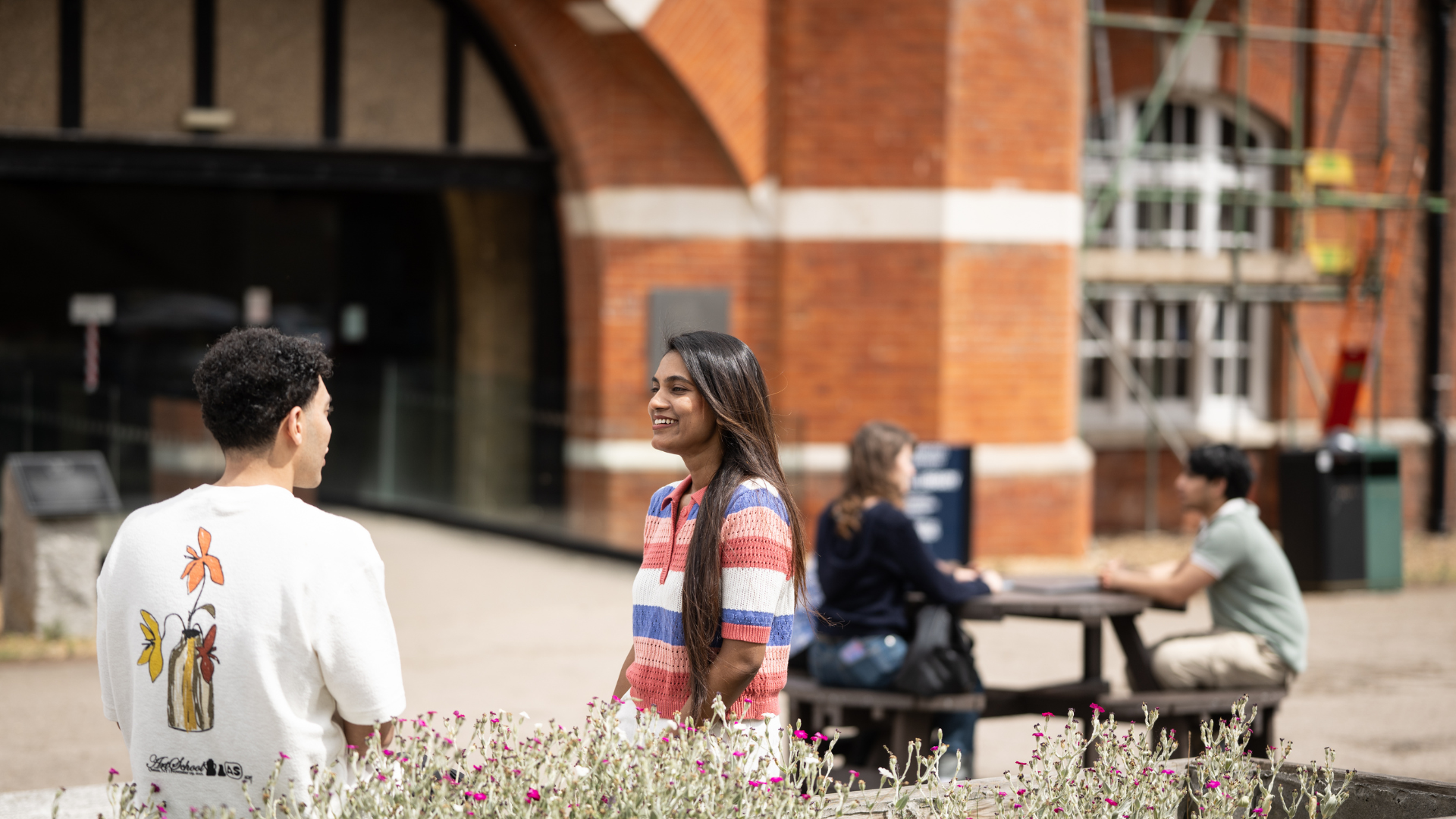 students smiling mid conversation outside of drill hall library at Medway